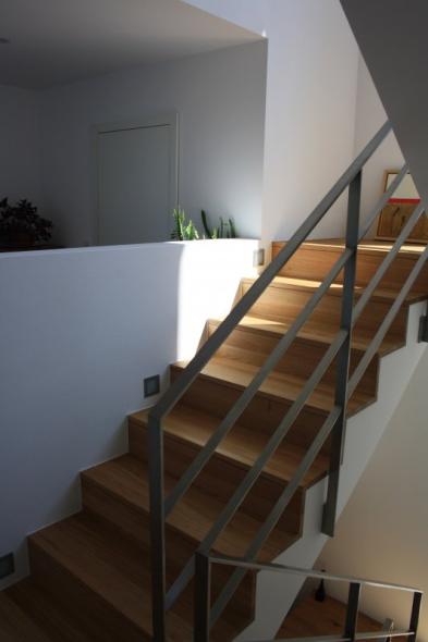 Treppe in weiß mit Eichenstufen und Metallgeländer mit Trockenbauwand